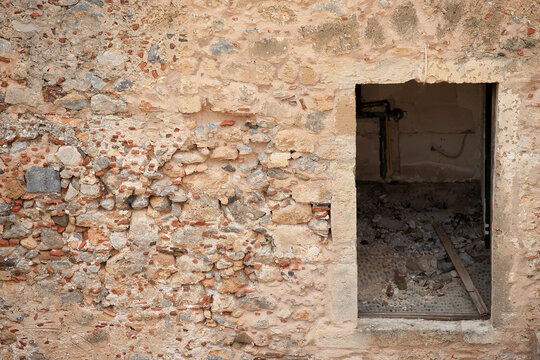 Monemvasia (Peloponnese, Greece) - The old stone wall and window hole in an old tenement hous.