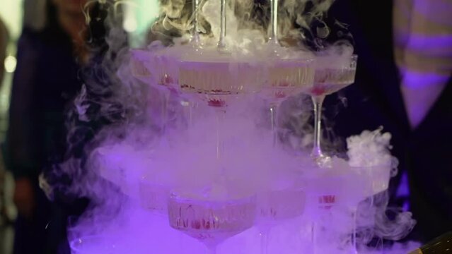 Tower of glasses at celebration party. Welcome drinks, tower of champagne or sparkling wine with red berry. Restaurant ready for reception. Alcoholic beverage.