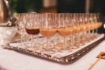Glasses of liquor on a silver tray.