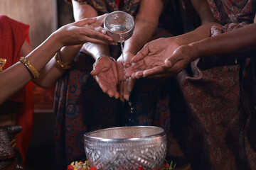 Pour water on the hands of revered elders and gives blessing , Thai woman with traditional dress respect to elder ,Songkran festival