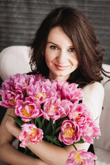 Young woman with a bouquet of pink tulips.