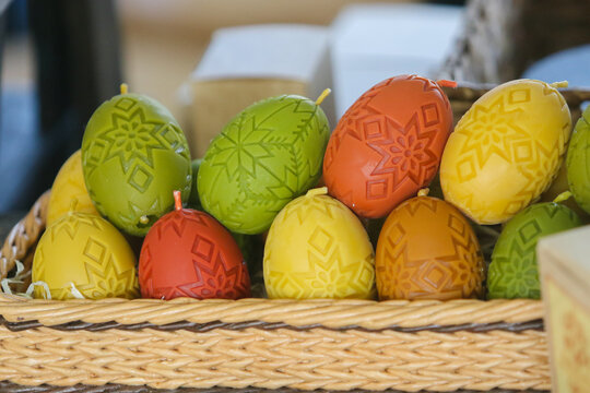 Paraffin figurines in the form of eggs and candles on the table during the celebration of Easter