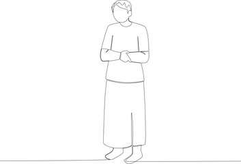 A man praying stands folding his hands