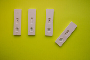 Negative and positive pregnancy tests on yellow background. Long-term motherhood, happiness....