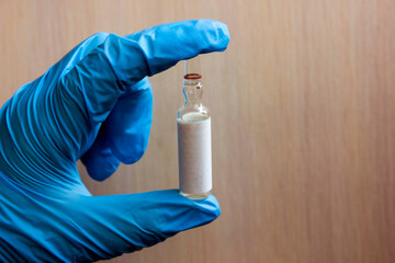 Concept of controlling the coronavirus virus, doctor or scientist in the laboratory holds a syringe with liquid vaccines for children or the elderly, concept: disease, medical care, science.