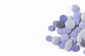 Assorted pills on a neutral background with light blue colors.