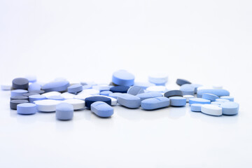 Assorted pills on a neutral background with light blue colors. Concept of pills used for male erection.