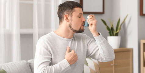 Sick man using inhaler at home