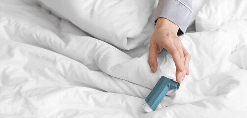 Sick woman with inhaler in bedroom, closeup
