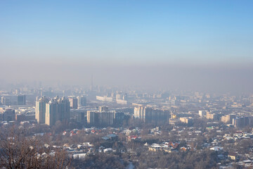 Fototapeta premium View of Almaty city from Kok Tobe mountain on winter afternoon. Foggy Almaty city view at winter in Kazakhstan, Central Asia