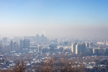 View of Almaty city from Kok Tobe mountain on winter afternoon. Foggy Almaty city view at winter in Kazakhstan, Central Asia