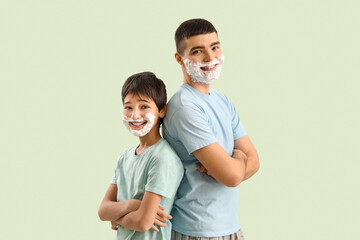 Obraz premium Man and his little son with shaving foam on faces against light color background