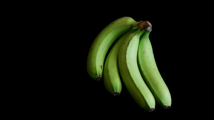 Fresh ripe green plantain bananas on a dark background. Copy space © slexp880