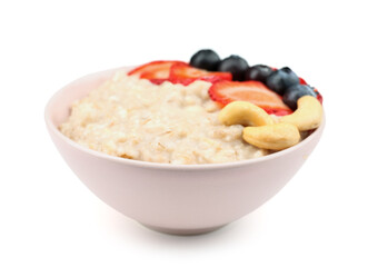 Bowl with tasty oatmeal, strawberries, blueberries and cashew isolated on white background