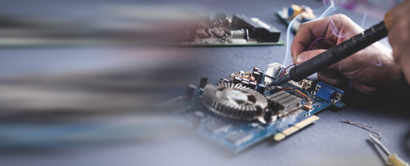 Fototapeta premium Computer hardware engineering. Engineer soldering computer motherboard