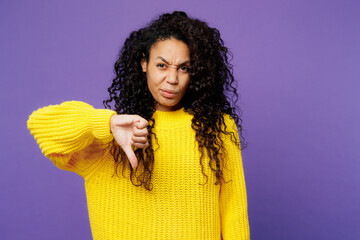 Young dissatisfied displeased sad woman of African American ethnicity wear casual yellow sweater...