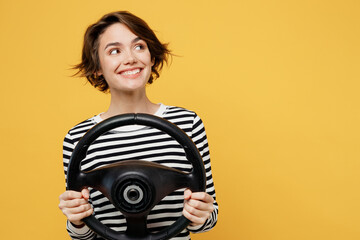 Young smiling fun cool woman wear casual striped black and white shirt hold steering wheel driving...