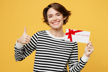 Young woman wears casual striped black and white shirt hold gift certificate coupon voucher card...