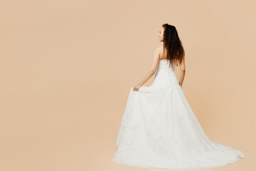 Full body back rear view beautiful young woman bride wear wedding dress posing in long white gown...
