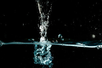 Water surface with bubbles on black background.