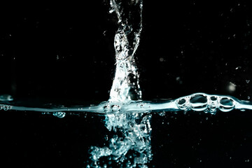 Water surface with bubbles on black background.