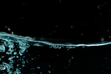 Water surface with bubbles on black background.