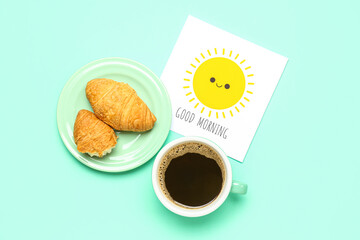 Card with text GOOD MORNING, tasty croissants and cup of coffee on color background