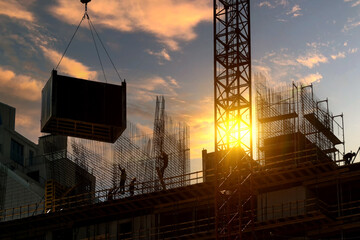 Construction of a new modern residential complex against the backdrop of a beautiful sunset sky with clouds.