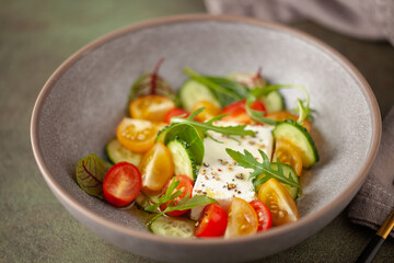 Easy greek salad of fresh cucumber, tomato, arugula,  feta cheese  with olive oil. Healthy food.