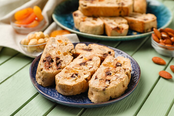 Plate with tasty biscotti cookies on color wooden table, closeup