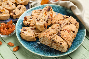 Plate with tasty biscotti cookies and almonds on color wooden table, closeup