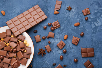 Composition with pieces of tasty chocolate and candies on dark color background