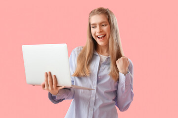 Naklejka premium Happy female programmer with laptop on pink background