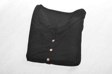 Black button down shirt folded on white background