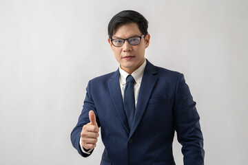 Portrait of confident Asian businessman in glasses showing thumbs-up isolated on white background
