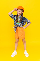 The child is an engineer in a helmet and shirt. A little girl is getting ready for renovation in the children's room.  A teenager chooses the profession of an architect. Yellow isolated background.