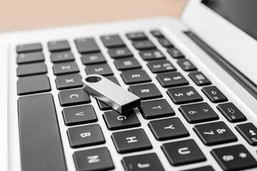 USB flash drive on modern laptop, closeup