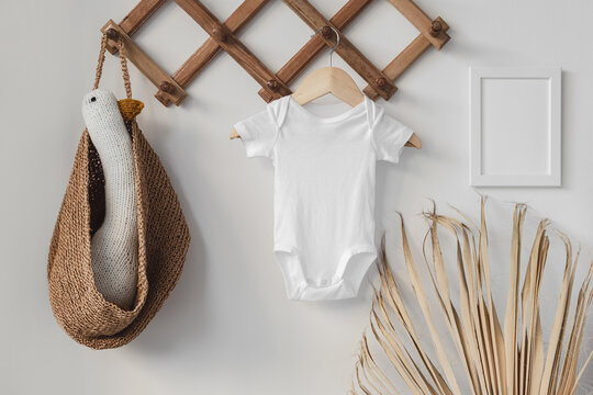 Minimalist white baby short sleeve bodysuit mockup for presentation cute sublimation designs. Minimalistic photos of romper for toddlers in scandinavian boho interior with minimalistic decoration