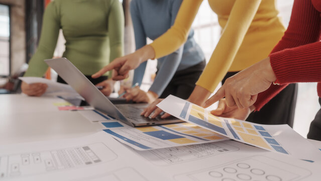 Group of ui ux developer brainstorming website wireframe mobile interface design on desk table.