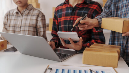 Team of smes warehouse checking email and writing on parcel cardboard box, Small business entrepreneur, SME, freelance online sellers, influencer and the team behind the work.