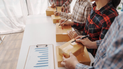 Team of smes warehouse checking email and writing on parcel cardboard box, Small business entrepreneur, SME, freelance online sellers, influencer and the team behind the work.