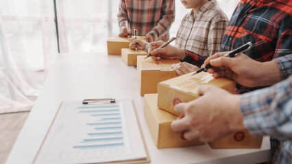 Team of smes warehouse checking email and writing on parcel cardboard box, Small business entrepreneur, SME, freelance online sellers, influencer and the team behind the work.