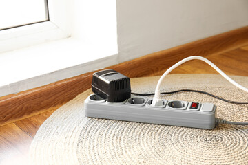 Electric extension cord with plugs on carpet