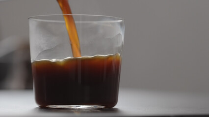 pour coffee in tumbler glass on concrete countertop with copy space