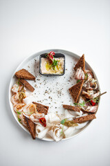 Ukrainian lard on a plate with dark bread on a white background
