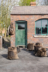 A 1900's coal yard office and weighbridge with sacks of coal outside ready for sale.