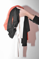 Woman's hands holding clothes on a white background