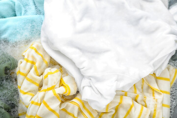 Wet clothes with laundry detergent, closeup