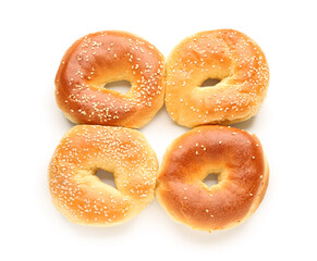 Tasty bagels with sesame seeds on white background