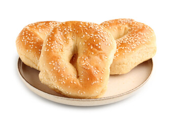Plate of tasty bagels with sesame seeds on white background